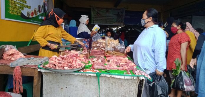 HARGA MAHAL : Salah satu penjual daging sapi di pasar kebon roek tengah melayani pembeli hari ini.(DEVI HANDAYANI/RADAR LOMBOK)