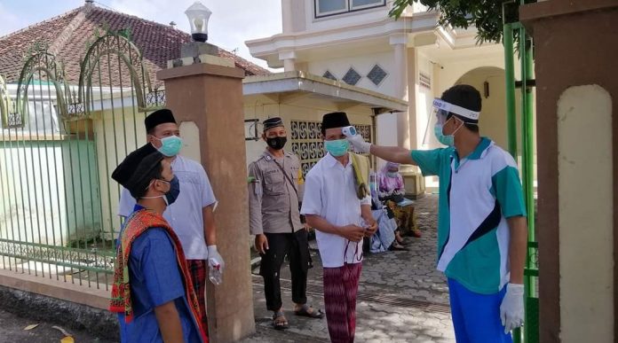 PENGUKURAN SUHU : Petugas melakukan pengukuran suhu badan kapada jamaah di salah satu masjid di Kabupaten Lombok Timur saat hendak menunaikan salat Jumat.( Janwari Irwan/Radar Lombok)