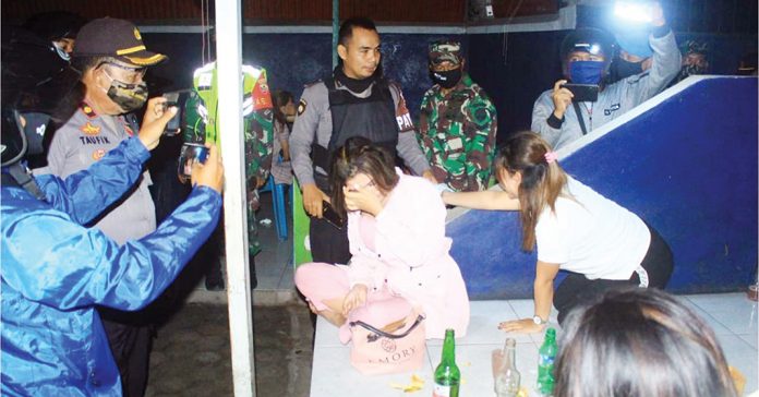 RAZIA: Muda-mudi yang ditemukan tengah minum-minuman keras di salah satu kafe di Lingkungan Sindu, Ckaranegara, Kota Mataram, diberikan peringatan dan dibubarkan petugas karena tidak mengindahkan protocol Covid-19. (DERY HARJAN/RADAR LOMBOK)