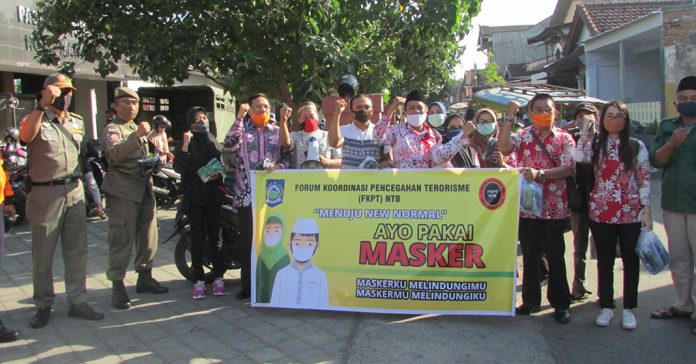 KEGIATAN SOSIAL: Pengurus FKPT NTB saat melakukan kegiatan sosial bagi masker di Perumnas Tanjungkarang Permai Mataram. (Tony/Radar Lombok)