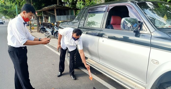 IDENTIFIKASI : Petugas SPKT Polresta Mataram melakukan identifikasi awal kasus pencurian modus pecah kaca mobil di Jalan R Soeprapto, Senin (13/7). (ALI MA’SHUM/RADAR LOMBOK)