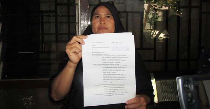 GUGATAN: Prayatiningsih, 52 tahun, menunjukkan surat gugatan warisan yang dilakukan anak kandungnya sendiri, Rully Wijayanto, Kamis (6/8). (M.HAERUDDIN/RADAR LOMBOK)